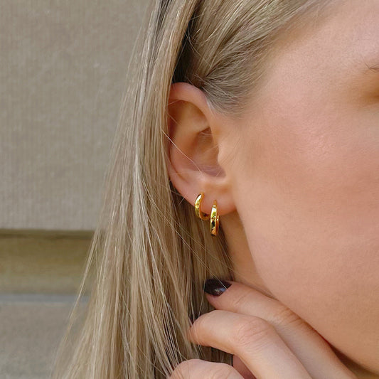 Gold-plated hoop earrings on ear, small and medium sizes with clasp backs