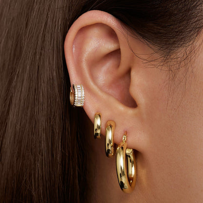 Gold-tone baguette hoop earring worn with matching hoop, stone row detail