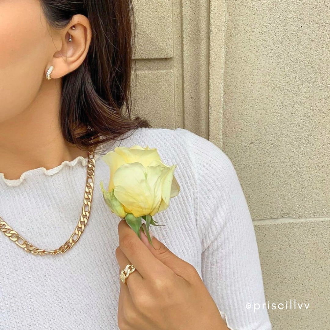Gold pavé huggie hoop earrings worn in the ear