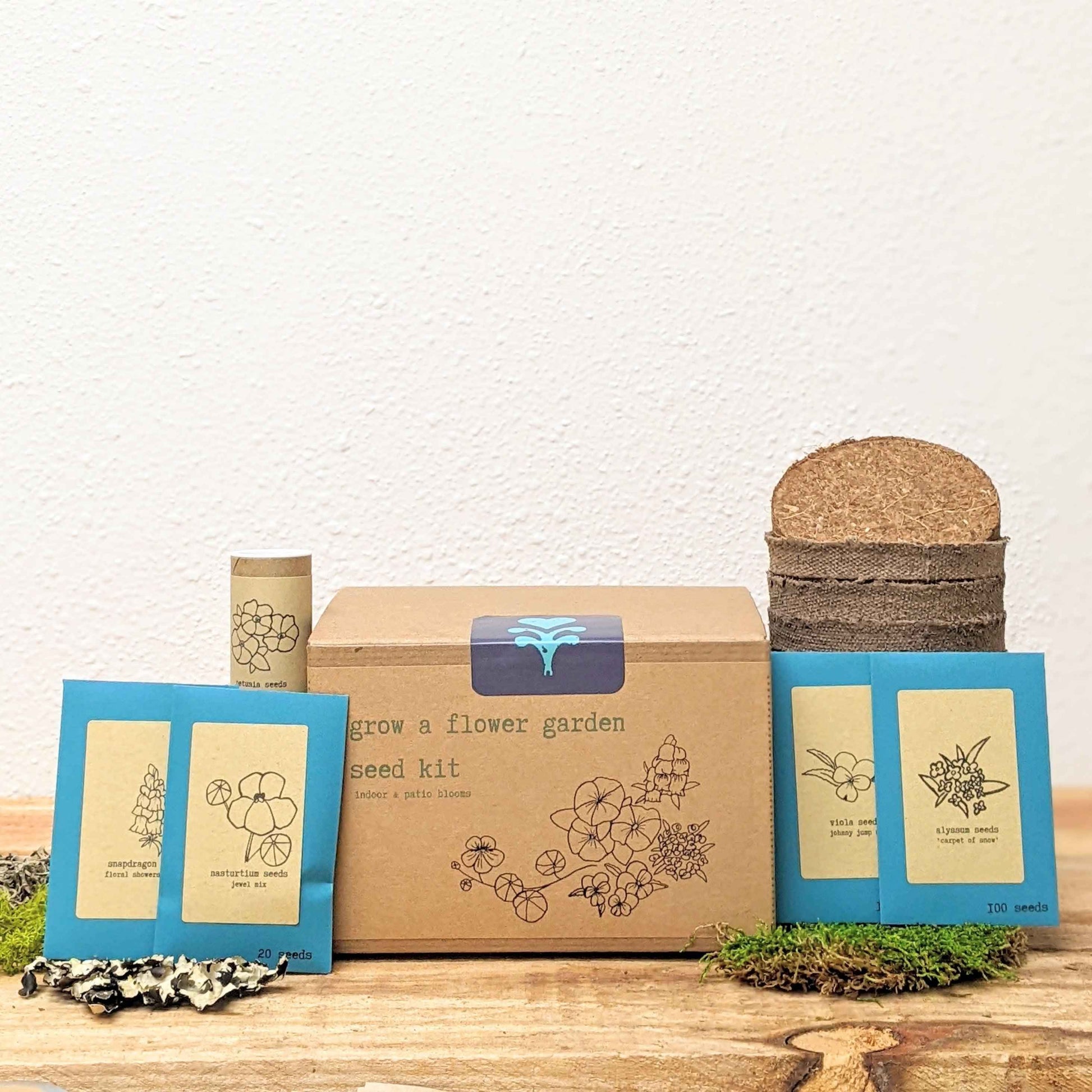 Flower seed kit box with blue seed packet sleeves and a stacked soil pot container