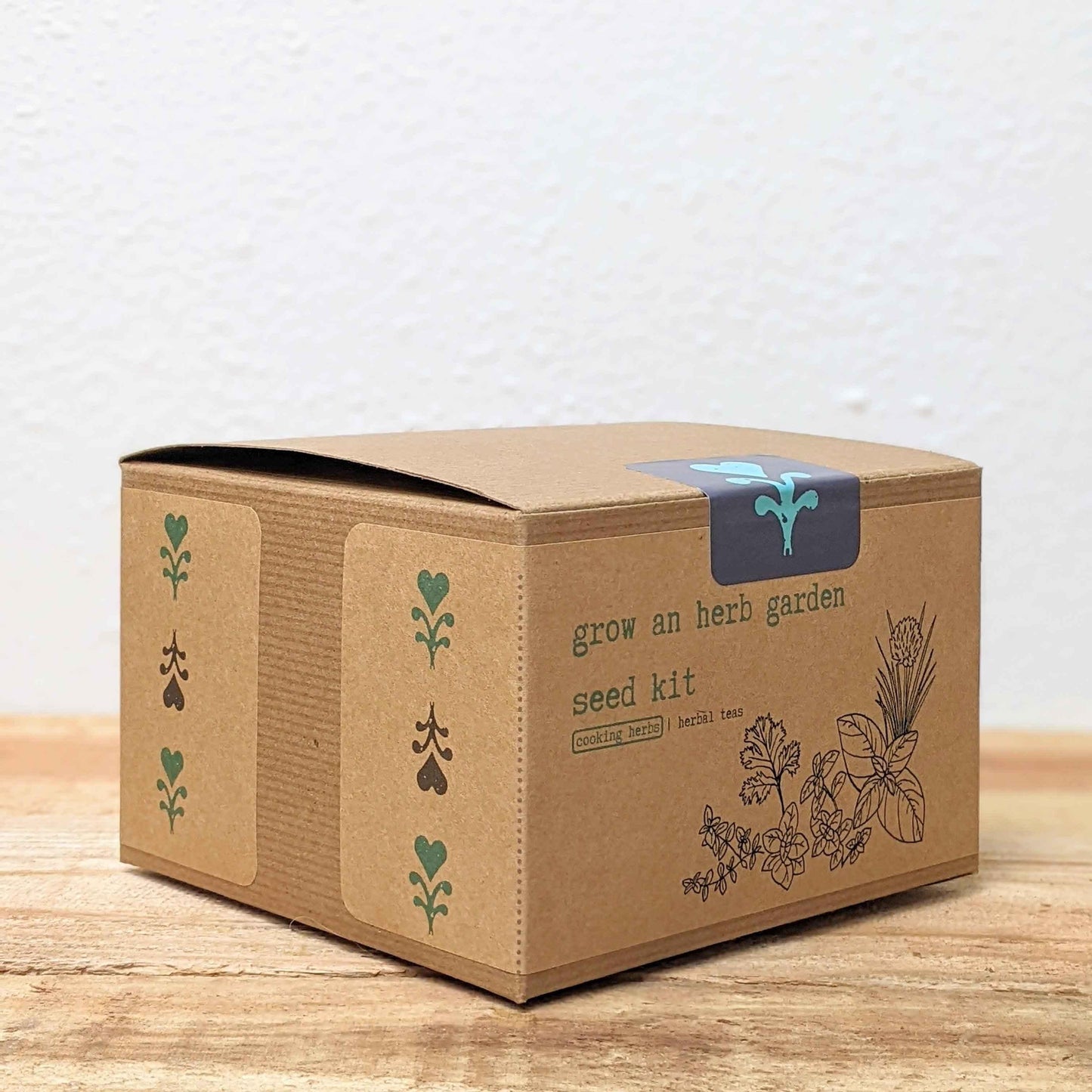 Herb seed kit box, brown cardboard with herb icons and 'grow an herb garden' label