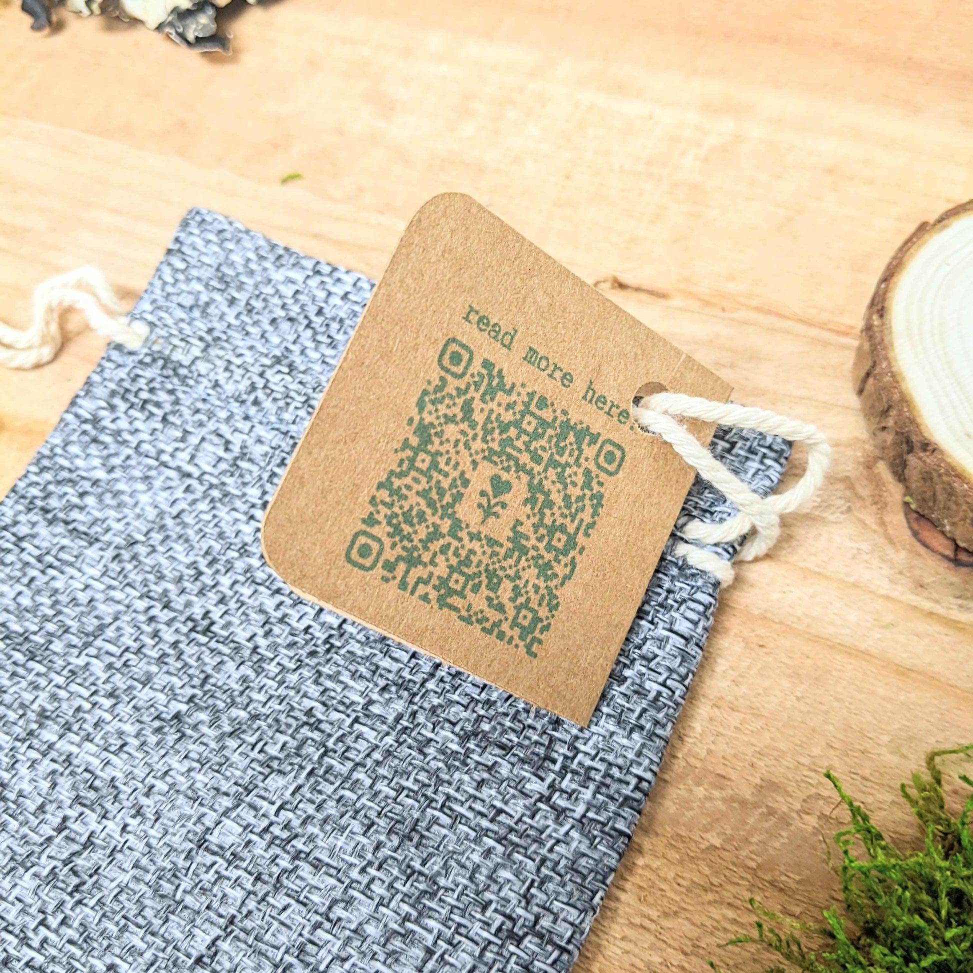 “Read more here” kraft seed packet with twine on blue woven pouch