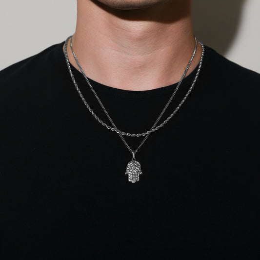 Silver hamsa pendant necklace set with two rope-link chains on a model