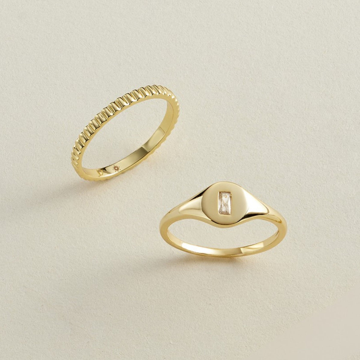 Gold-tone signet ring with baguette-cut crystal center on triangular top