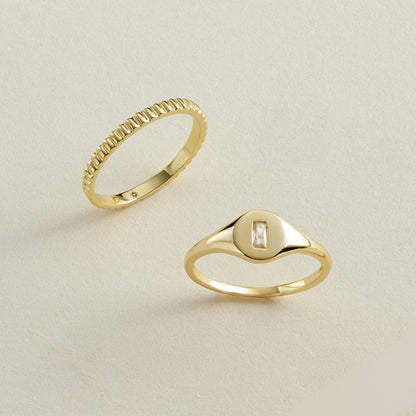 Gold-tone signet ring with baguette-cut crystal center on triangular top