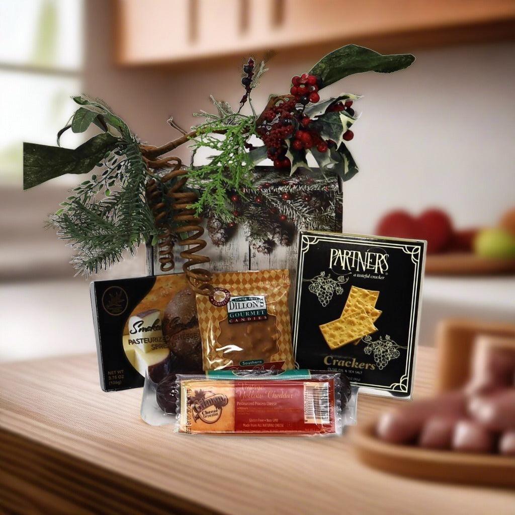 Holiday gift box with snacks and crackers, decorated with pine and red berries.