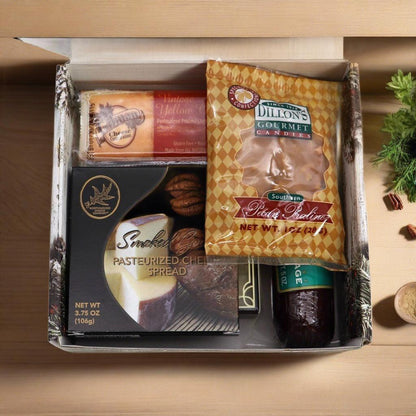 Open holiday gift box with cheese spread and candies, arranged in molded trays.