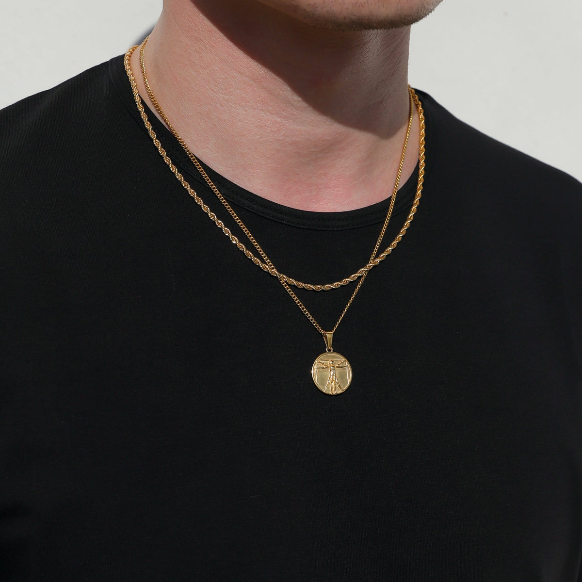 Gold-tone pendant necklace with two chains and circular medallion charm