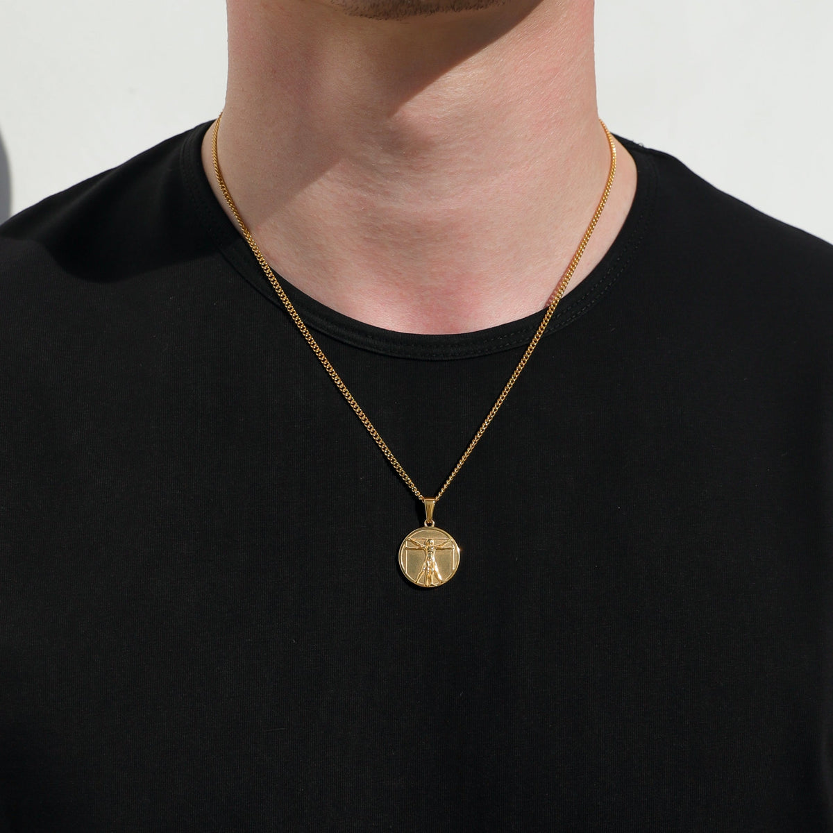 Gold-tone necklace with slim chain and circular medallion pendant