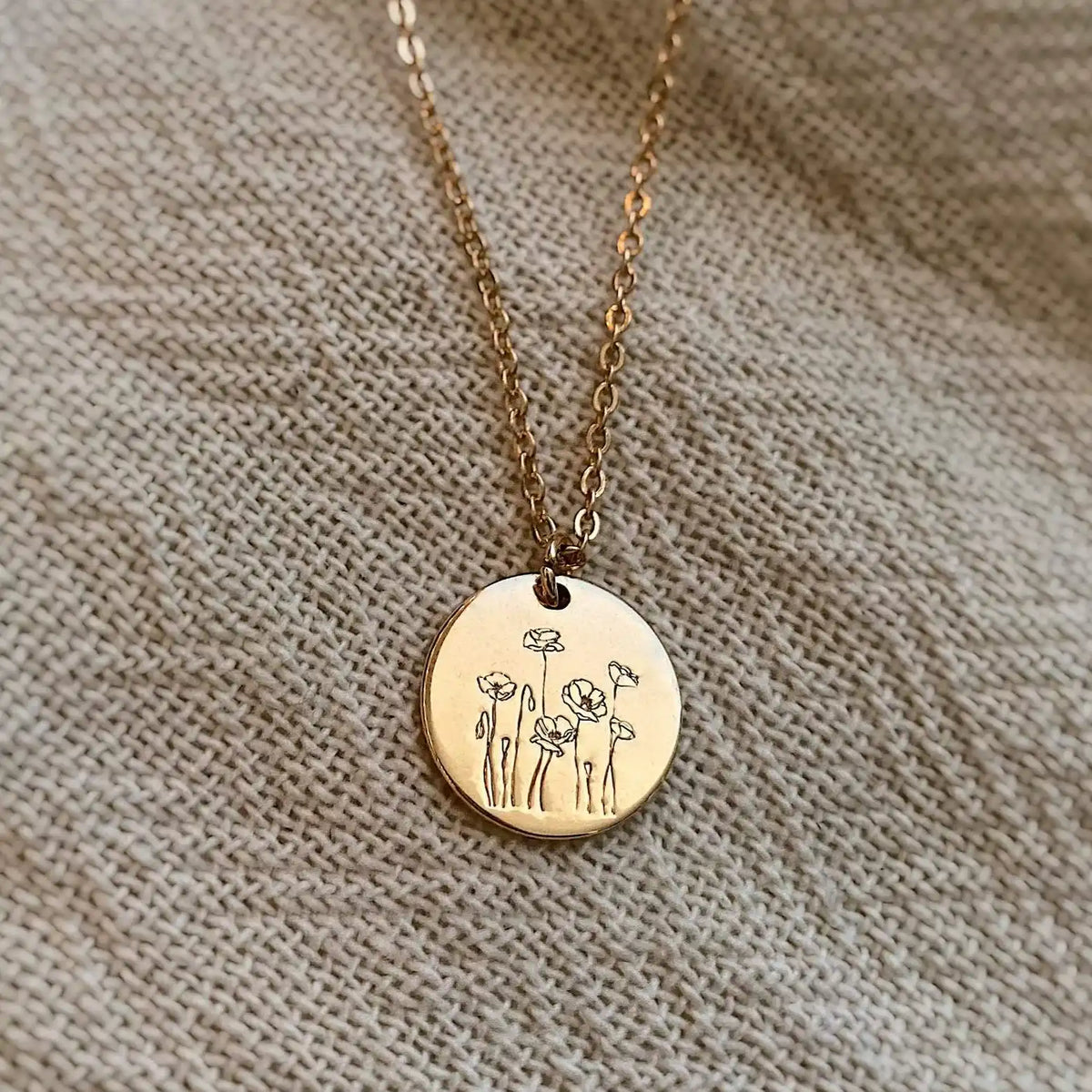 Gold-tone Poppy Necklace with round flower-engraved pendant and fine chain
