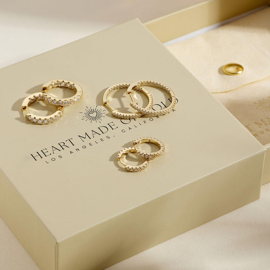 Gold hoop earrings set with three linked rings studded with clear stones