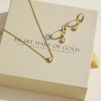 Gold-tone jewelry set: necklace and hoop earrings with round bezel-set diamonds