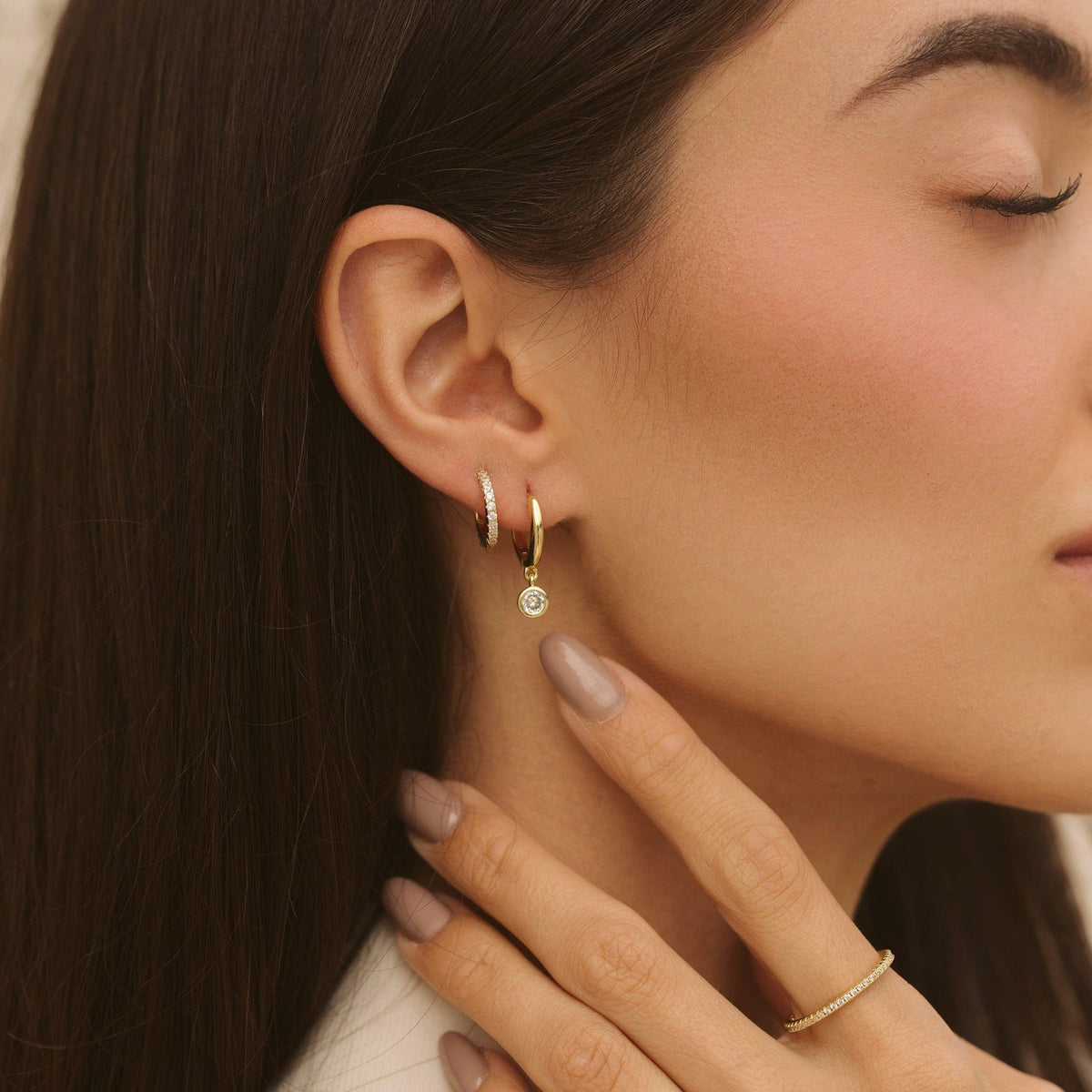 Gold-tone hoop earring with round bezel-set diamond dangle