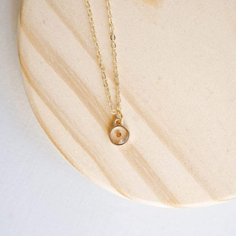 Gold mustard seed necklace with a round seed pendant