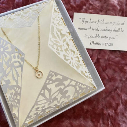 Gold mustard seed necklace displayed in a decorative gift box