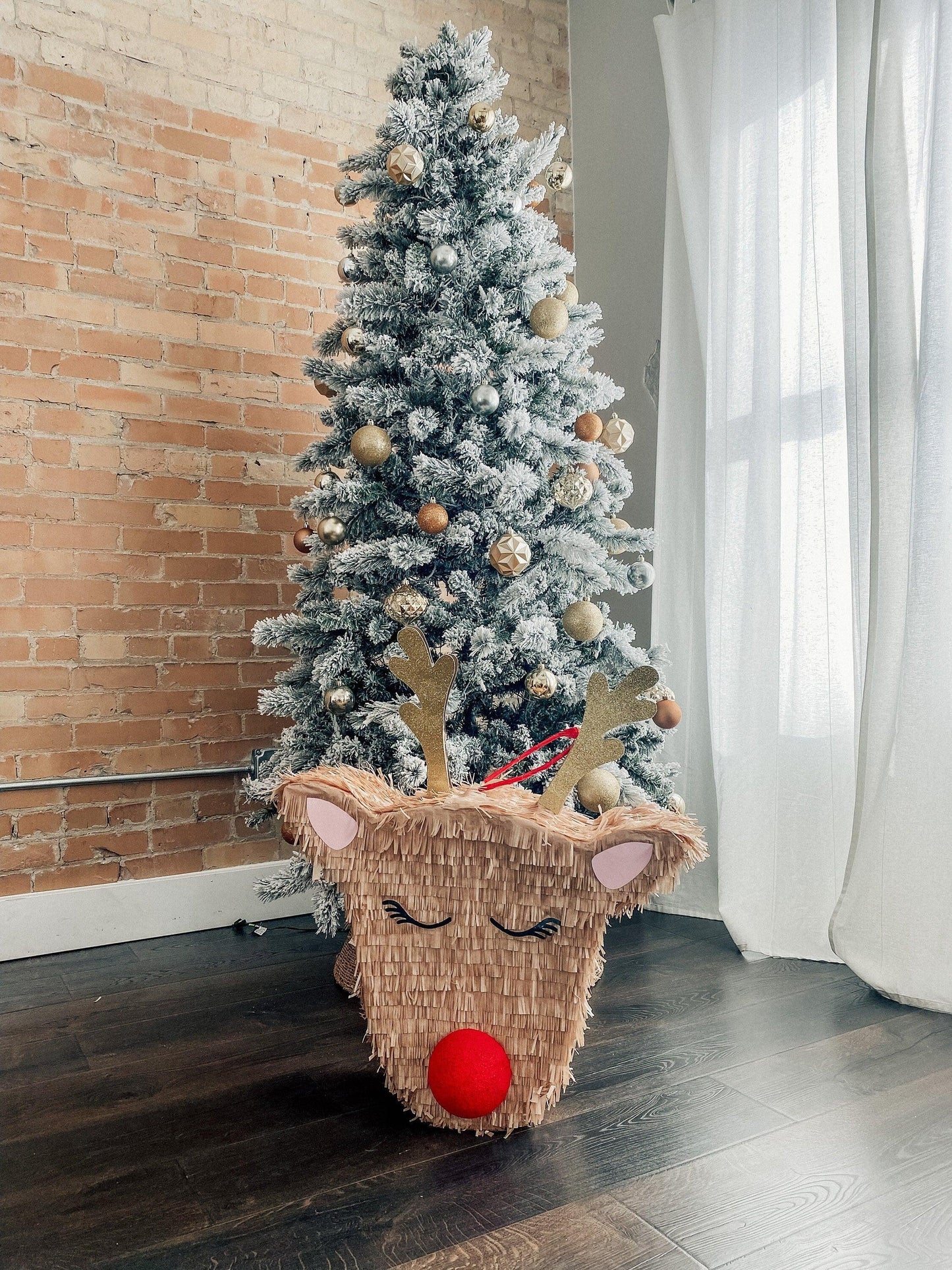 Rudolph reindeer piñata candy holder with fringe, antlers, closed eyes and red nose