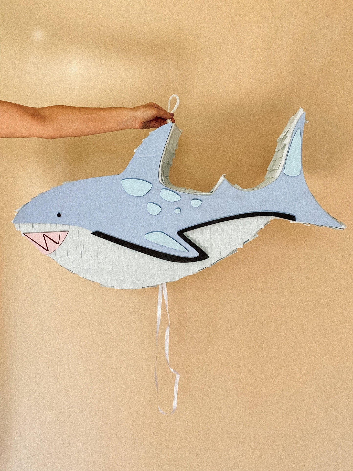 Blue and white handmade shark piñata candy holder with hanging string