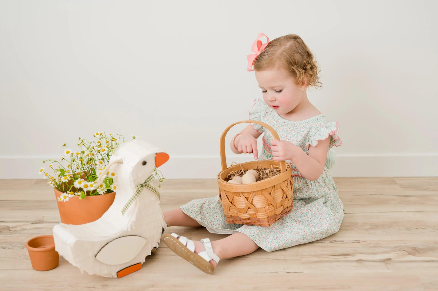 White goose piñata with orange feet accents and green plaid bow at the neck
