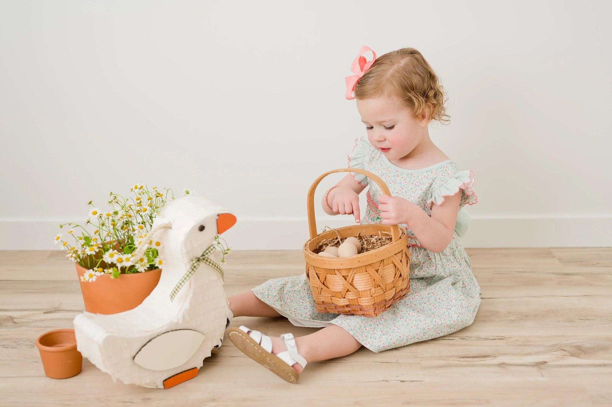 White goose piñata with orange feet accents and green plaid bow at the neck