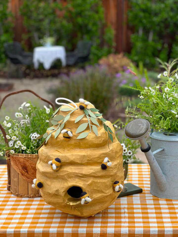Honey beehive piñata with leaf top and plush bees, standing decoration for party