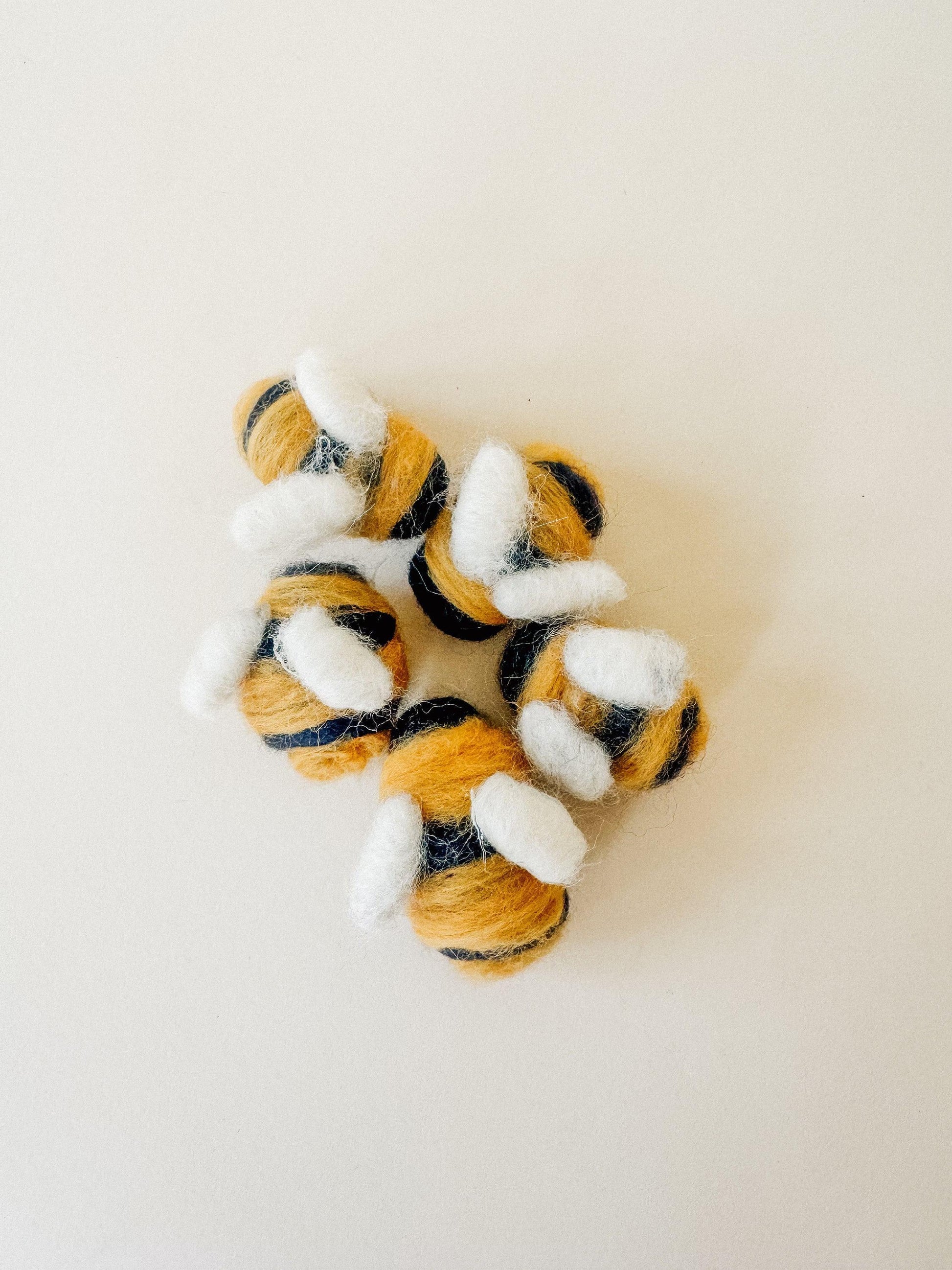 Close-up of plush bee decorations in yellow, black, and white felt