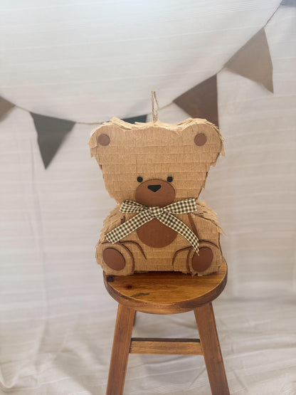 Front view teddy bear piñata, tan layered cardboard, brown muzzle, blue checkered bow