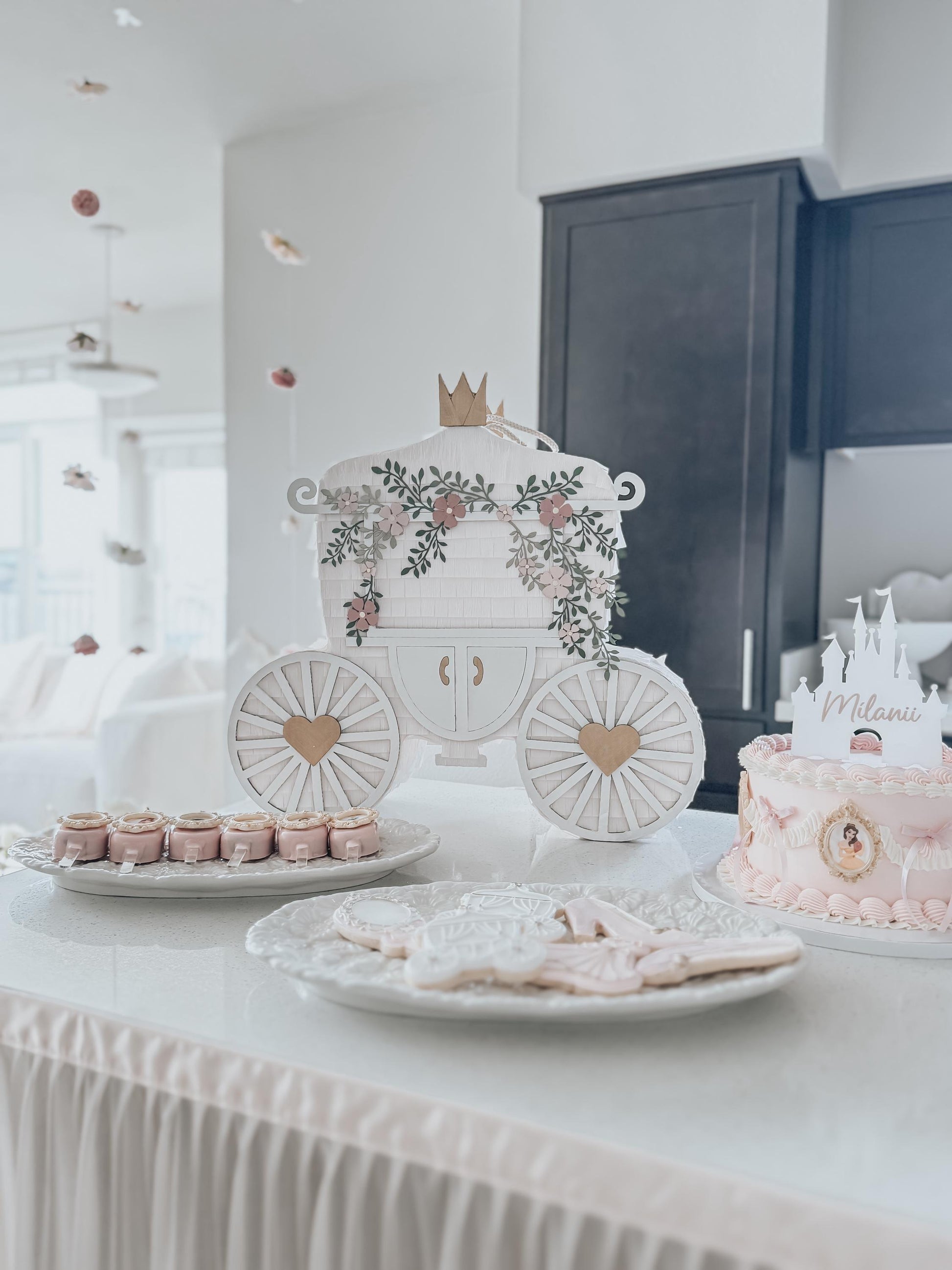 Regal princess carriage piñata with crown, floral arch, and heart wheel accents