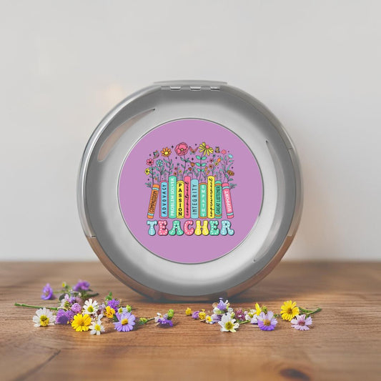 Silver compact travel mirror upright, showing a purple teacher-themed round design