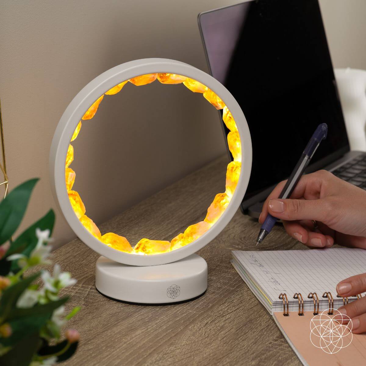 Citrine manifestation lamp with lit amber-gold ring, shown on a desk