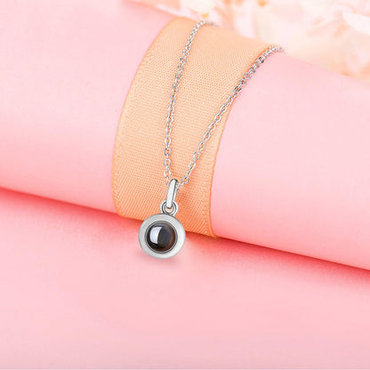 Silver photo projection necklace with round locket pendant and hanging chain