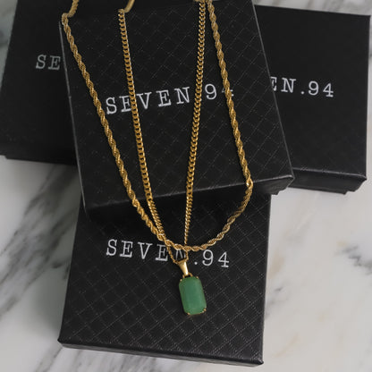 Gold-tone layered chain necklace set with green square stone pendant