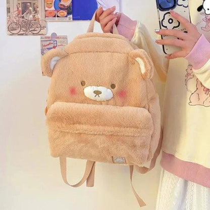 Light tan plush bear backpack with stitched face, front pocket, and small ear details