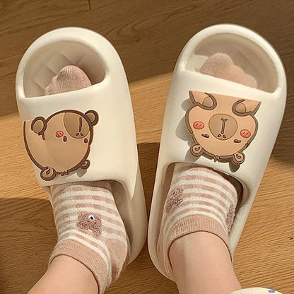 White capybara slide sandals with brown face graphic and striped socks.