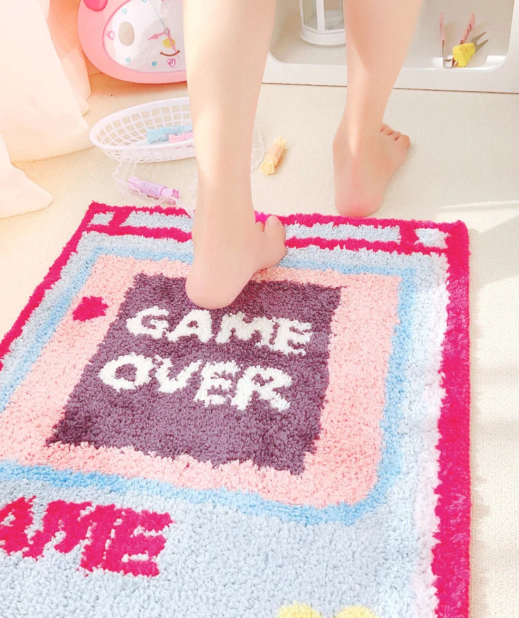 Game Over area rug in light blue with pink frame; small controller icons and hearts