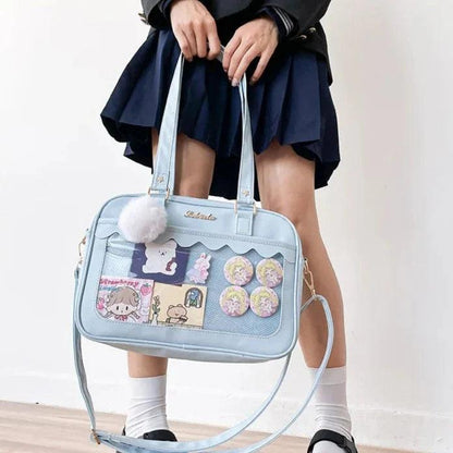Light blue Ita messenger bag with character collage window, scalloped flap, pom-pom charm