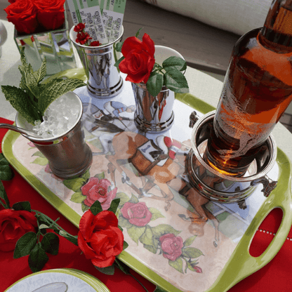 Horse-themed gift tray on table with two glasses of iced drinks and red roses