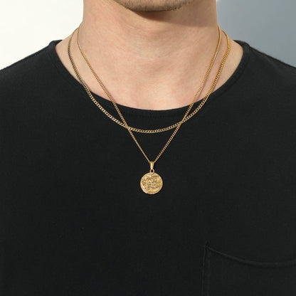 Gold coin pendant necklace with lion medallion on a man, layered chain look.