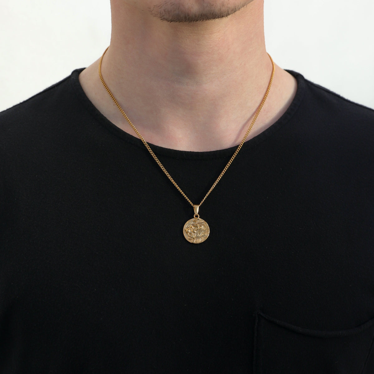 Gold lion medallion pendant necklace on an adult, showing short neckline drape.