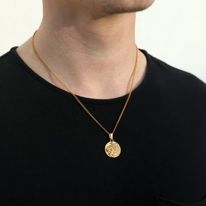 Gold coin pendant necklace with lion face medallion on a man, front view on black shirt.