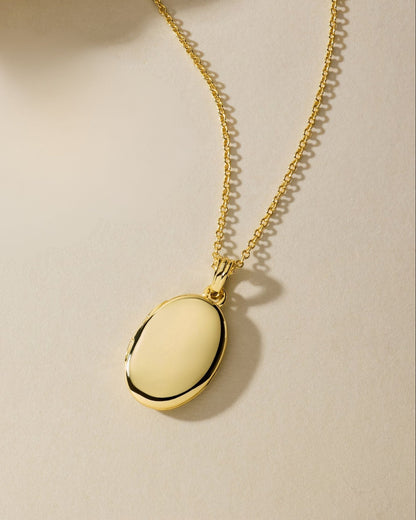 Gold oval locket pendant necklace with chain, polished oval front