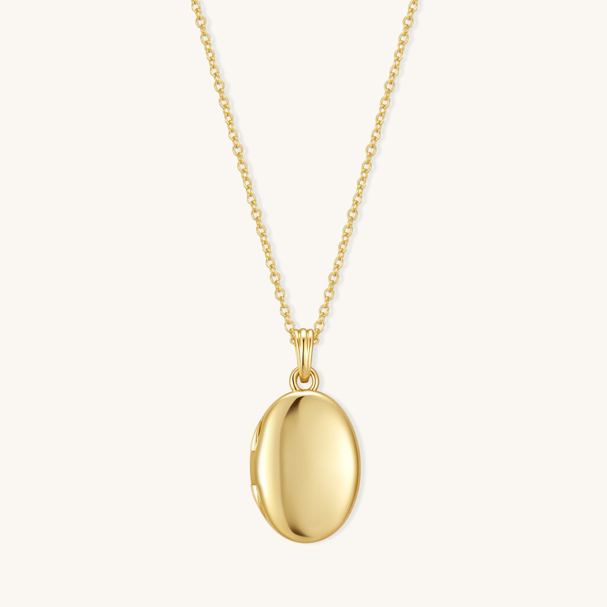 Gold oval locket pendant on chain with polished oval front