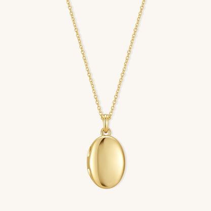 Gold oval locket pendant on chain with polished oval front