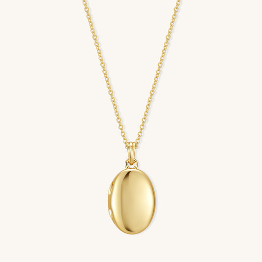 Gold oval locket pendant on chain with polished oval front