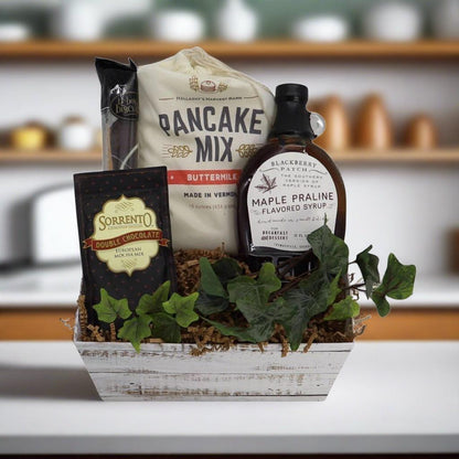 Breakfast gift basket with pancake mix, chocolate mix, maple-flavored syrup, and greens