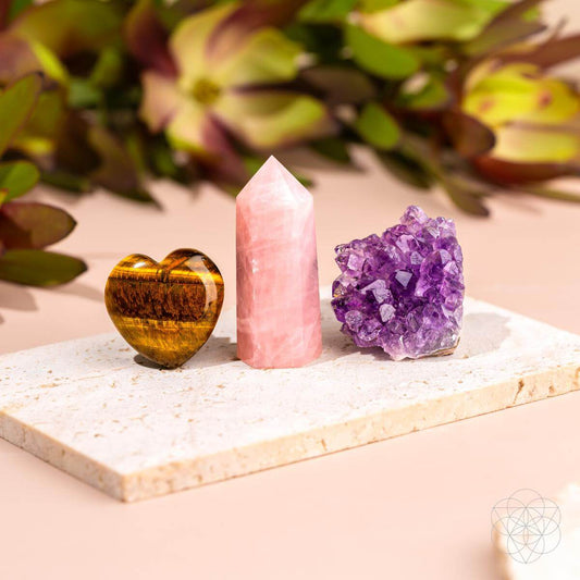 Crystal display set with pink quartz tower, tiger eye heart, and purple amethyst cluster
