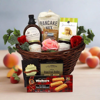 Wicker breakfast gift basket with pancake mix, syrup bottle, jam jars, and cookies