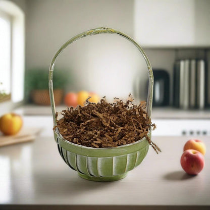 Gift basket with green woven handle and wood shavings filler, no items inside visible