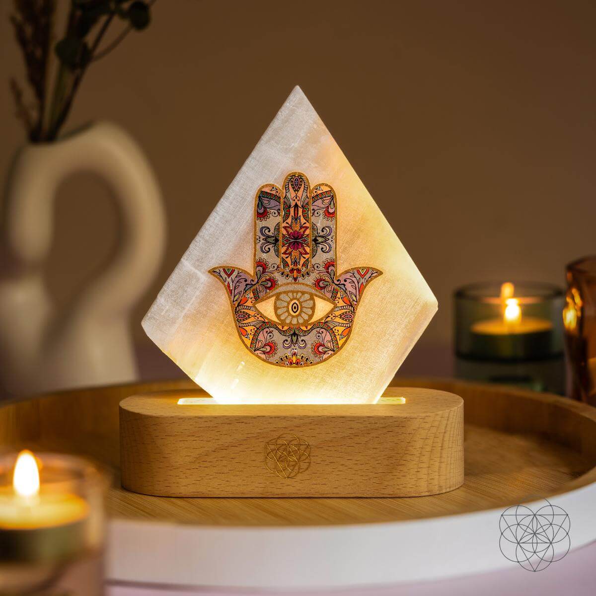 Glowing pyramid mood lamp with colorful Hamsa print on round wooden base
