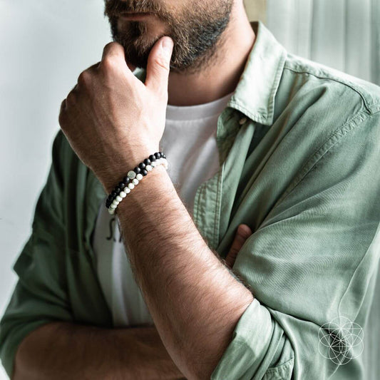 Man wearing black-and-white beaded bracelets with silver-tone metal spacers