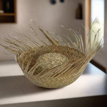Woven straw basket with tall grass bundle handle and rounded base